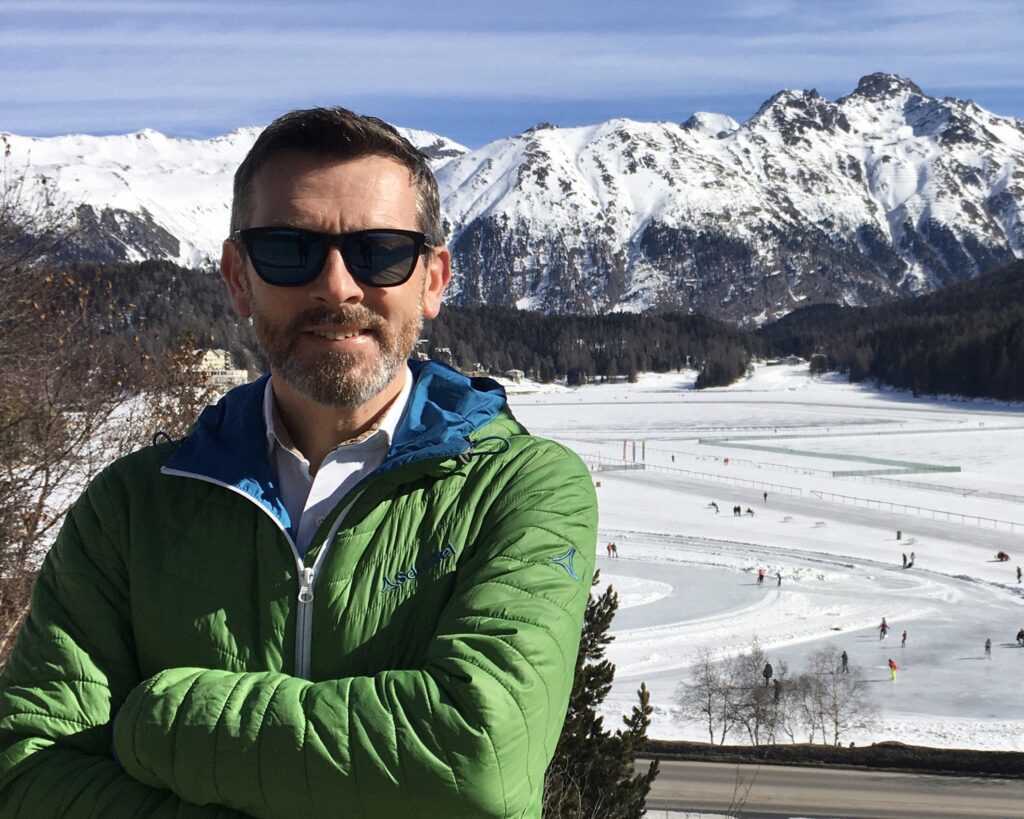 Man standing in front of snowy mountains