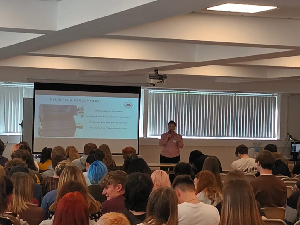 Zoe talking to a large room of young people 