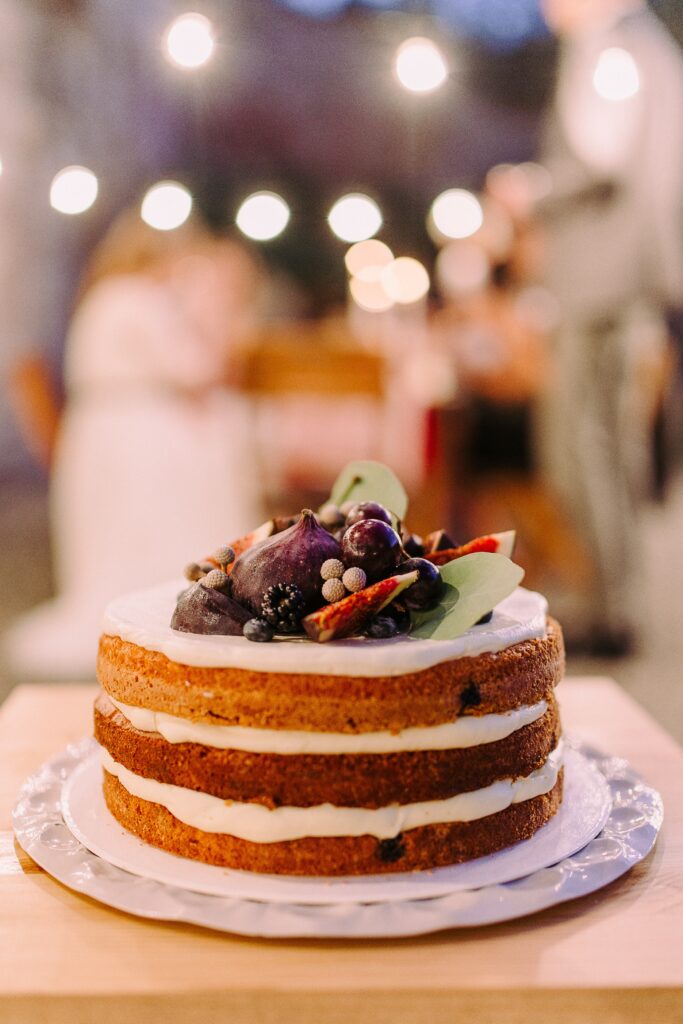 A three layer cake topped with fresh fruit 